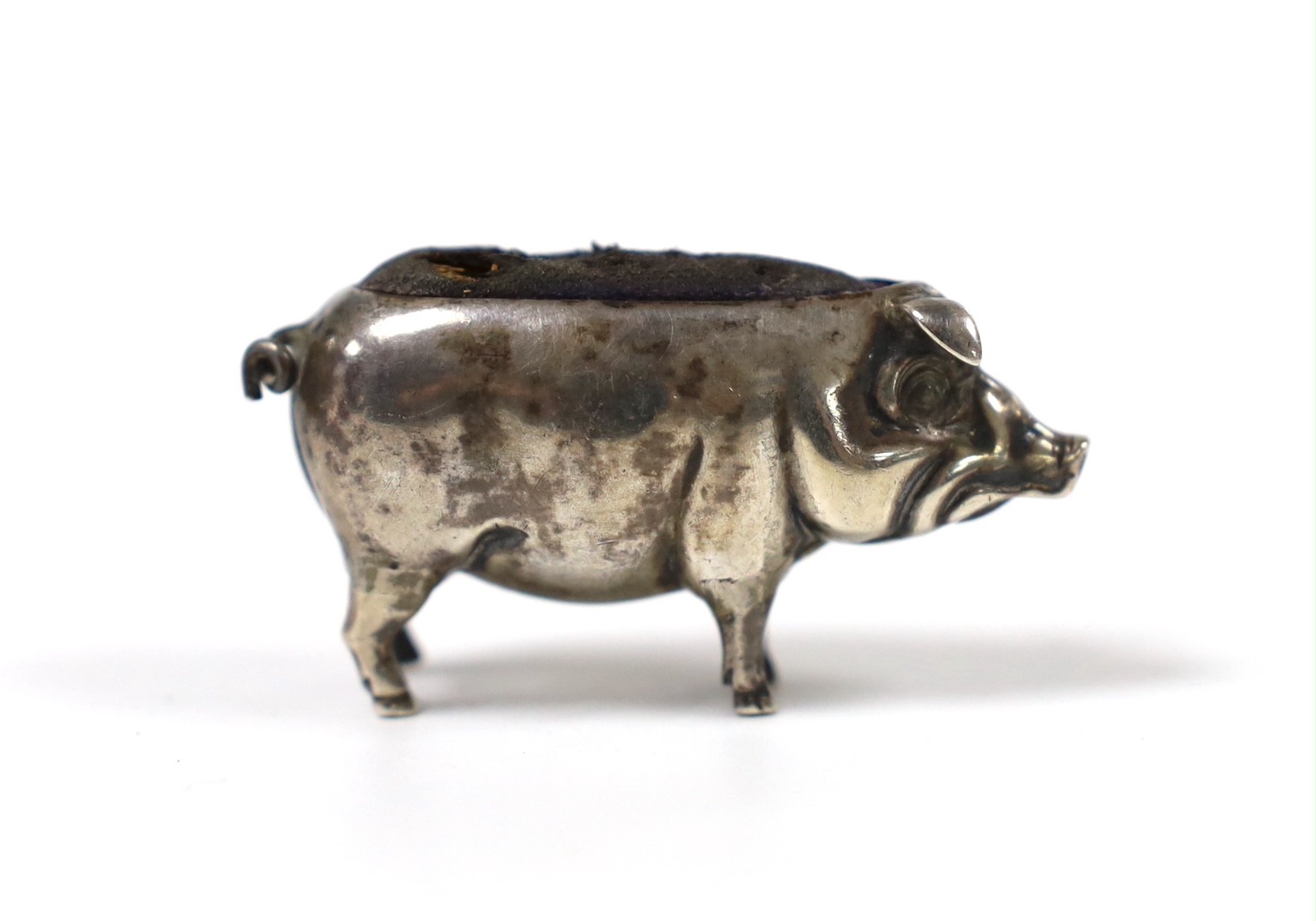 An Edwardian novelty silver mounted pin cushion, modelled as a pig, Saunders & Shepherd, Birmingham, 1905, length 47mm.